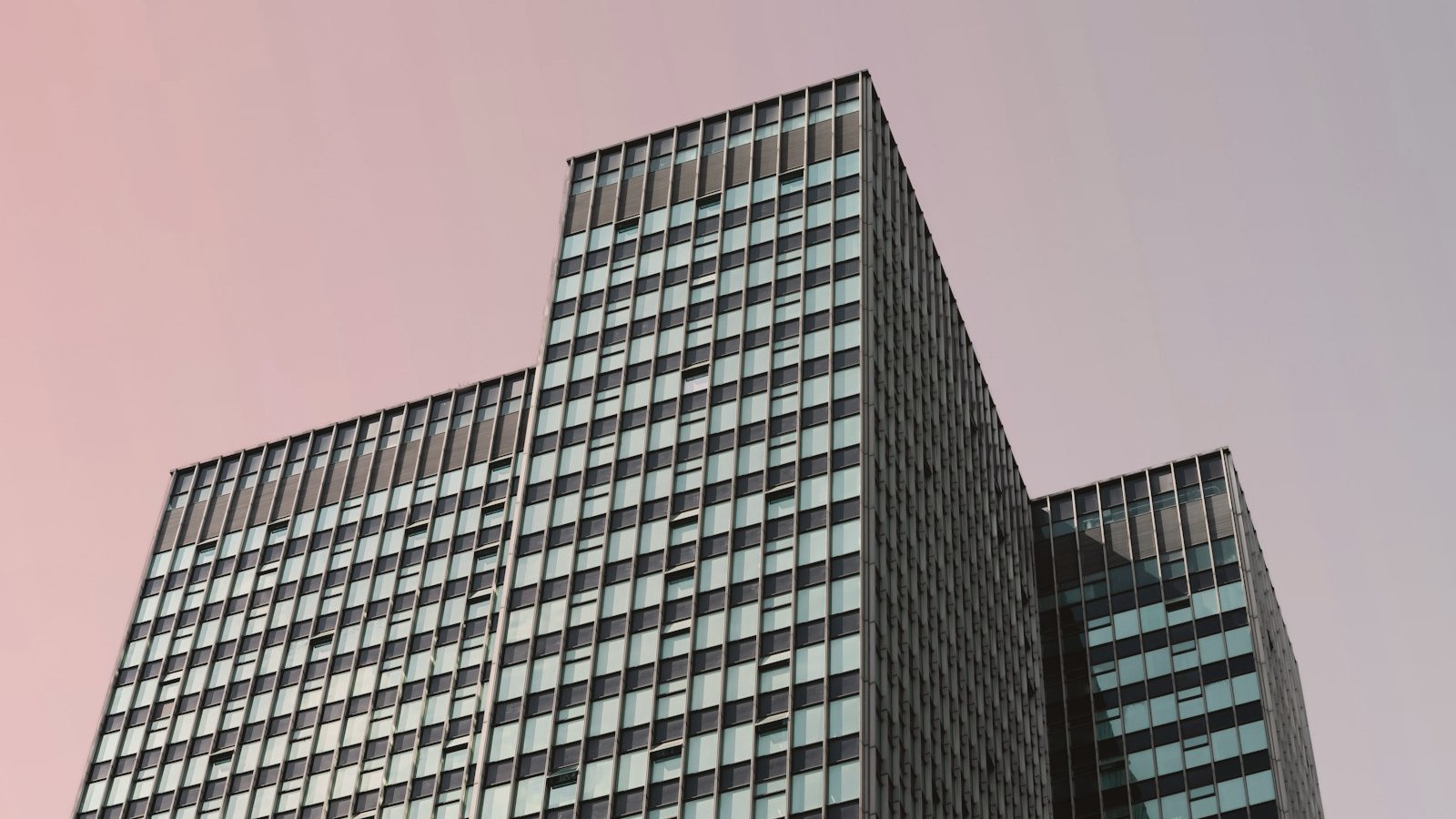 Architectural glass tower at dusk, anonymous corporate scale