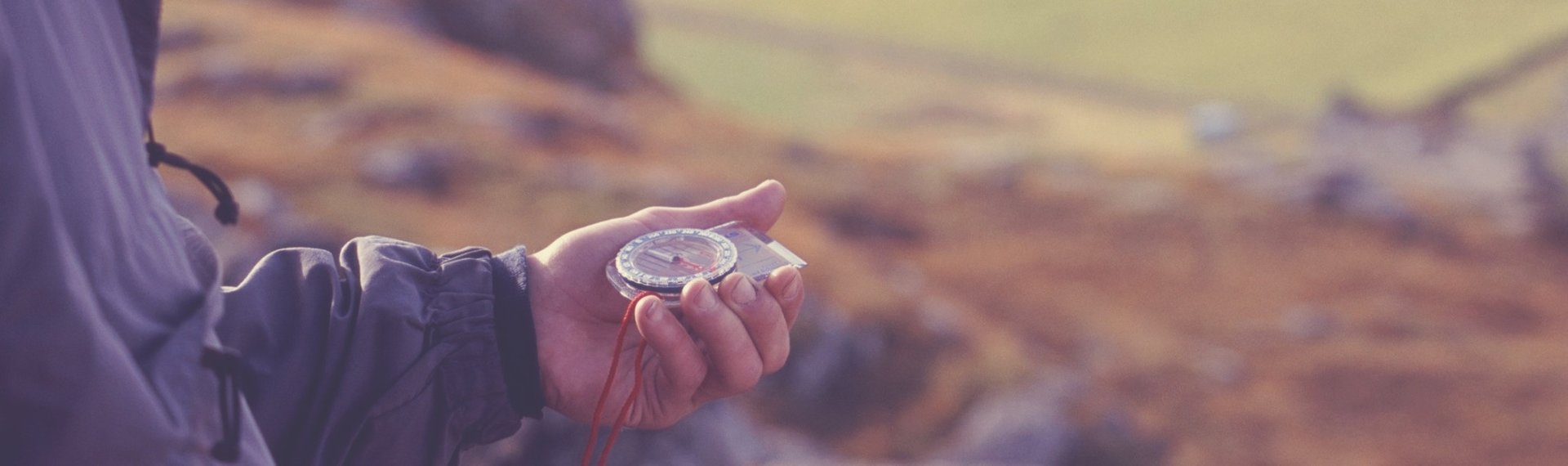 Compass in hand, landscape beyond